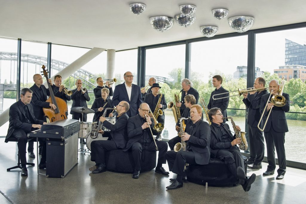 Die hr-Bigband und ihr Chefdirigent Jim McNeely (Mitte, stehend).© HR/Dirk Ostermeier".