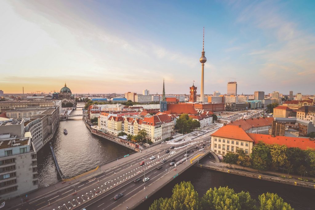 Blick über Berlin (Foto von <a href="https://unsplash.com/de/@florianwehde?utm_content=creditCopyText&utm_medium=referral&utm_source=unsplash">Florian Wehde</a> auf <a href="https://unsplash.com/de/fotos/stadtgebaude-in-der-nahe-von-gewassern-tagsuber-1uWanmgkd5g?utm_content=creditCopyText&utm_medium=referral&utm_source=unsplash">Unsplash</a>)